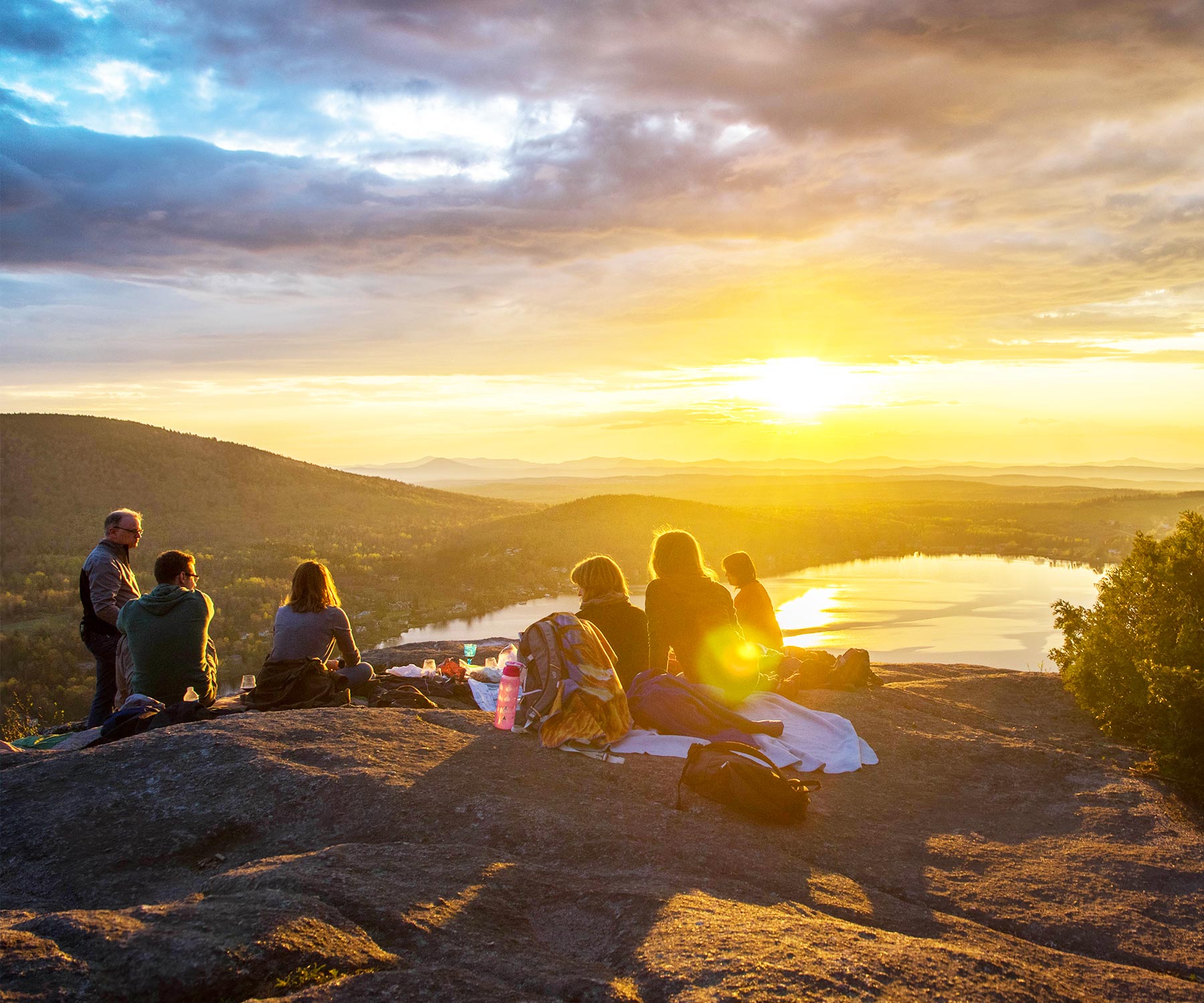 A family is enjoying the Sunrise or sunset at the top of the mountain